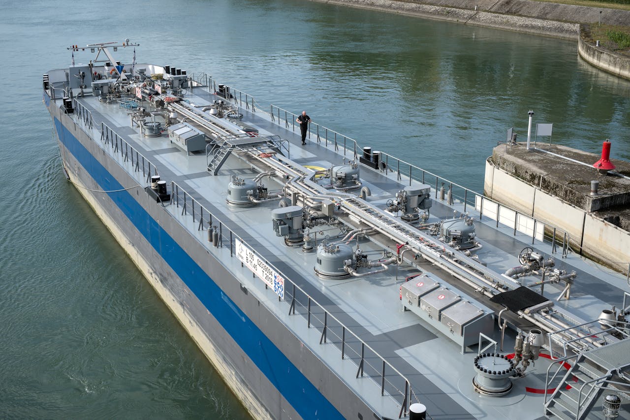 gallery-4 Aerial view of an industrial oil tanker docked at a harbor, showcasing modern maritime technology.
