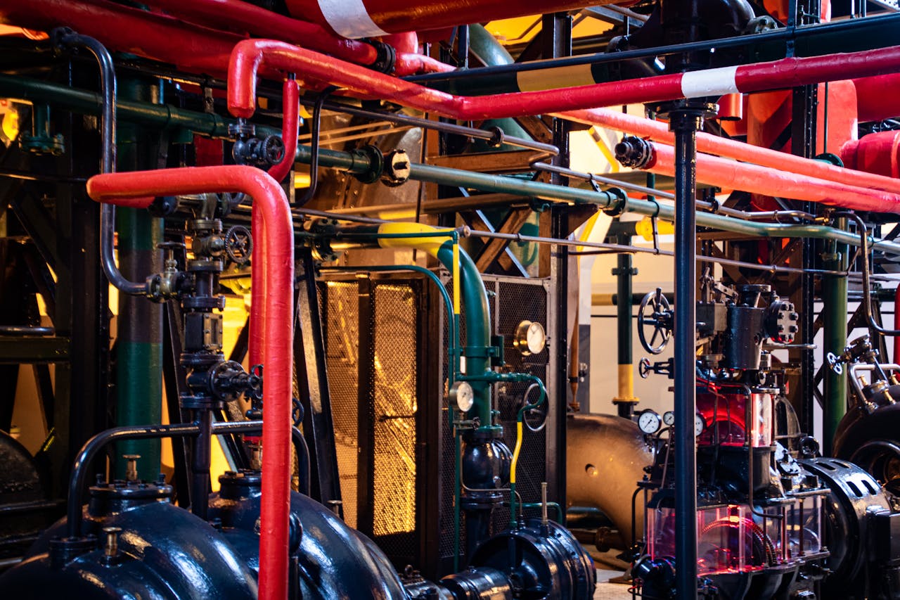 hero-img-01 Complex network of industrial pipes and machinery inside a Lisbon plant.
