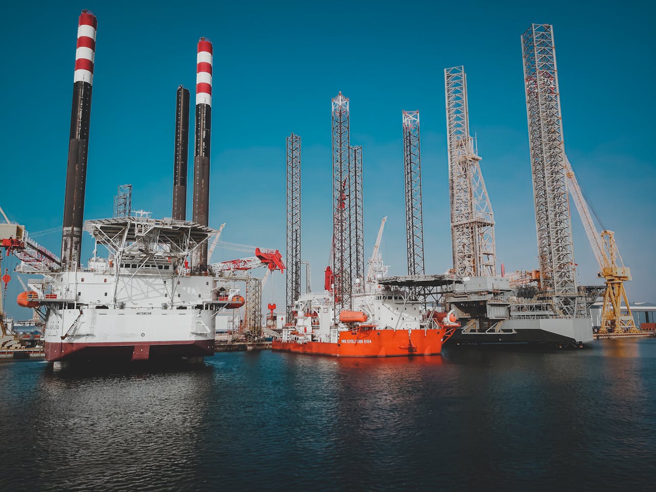 services-03 High angle view of offshore oil platforms in Ras Laffan, Qatar under clear blue sky.