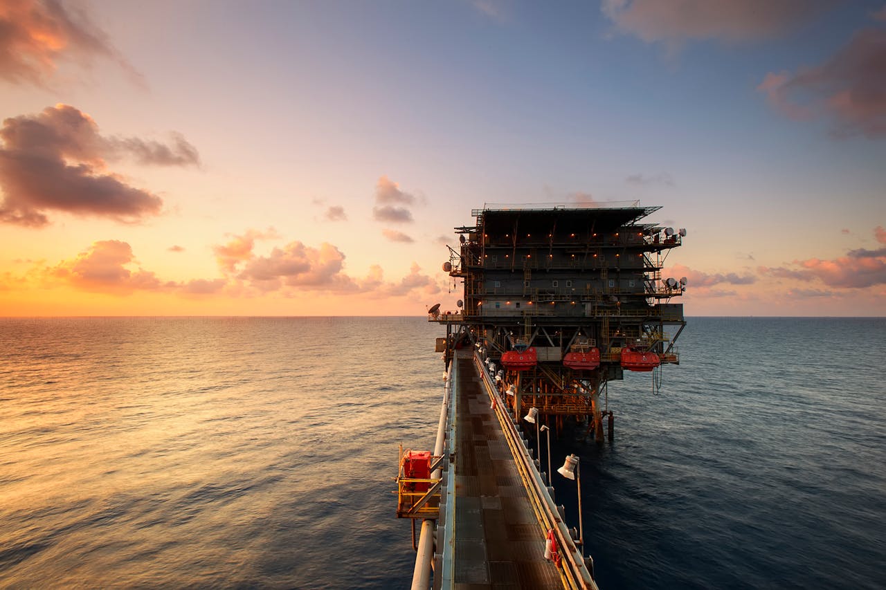 hero-img-02 A breathtaking view of an oil platform on the ocean at sunset, showcasing industrial beauty.